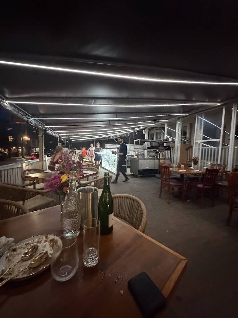 A covered outdoor dining terrace at night