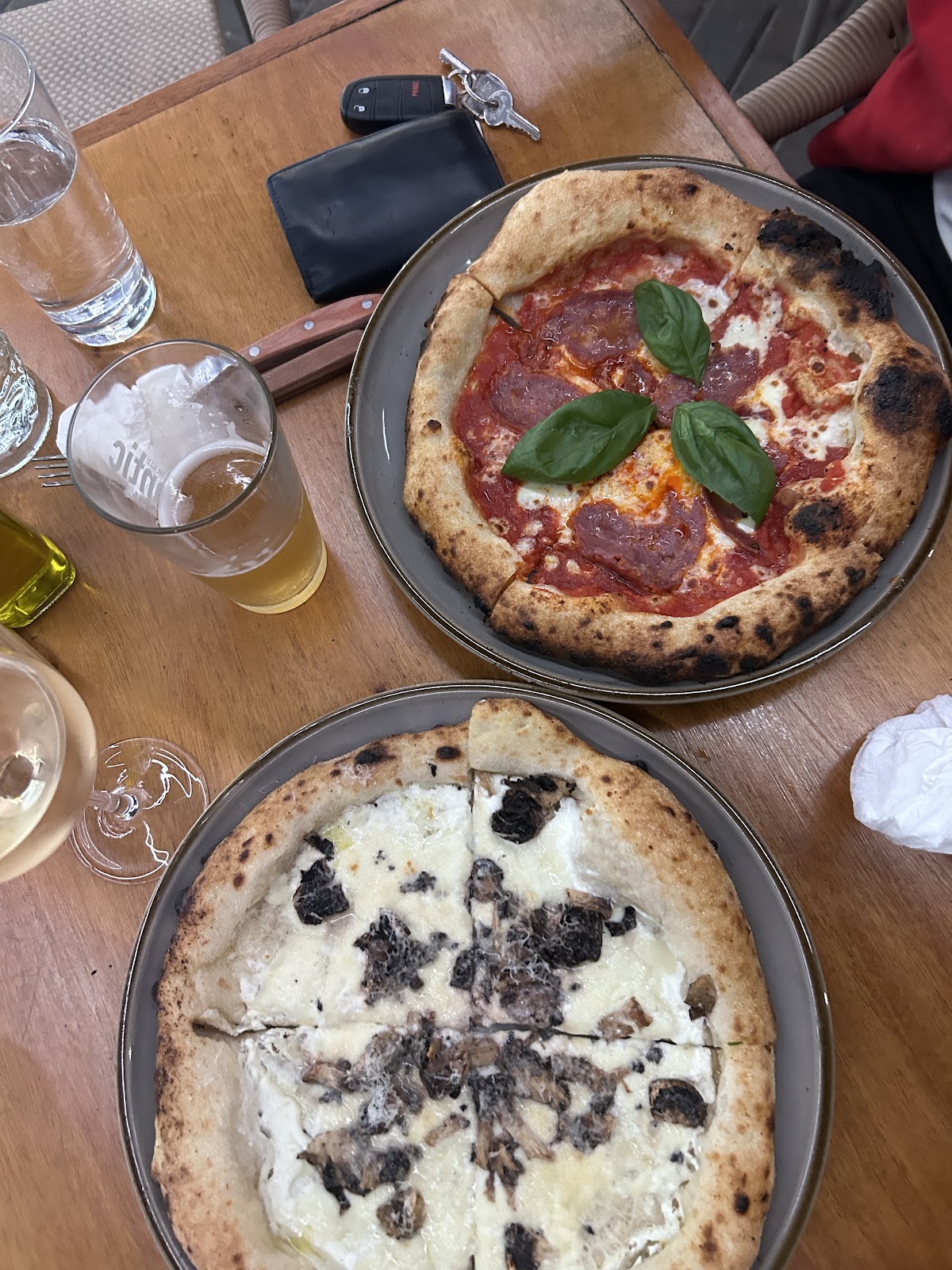 Two round dishes on a dining table with drinks and place settings